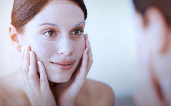 woman putting on a facial mask